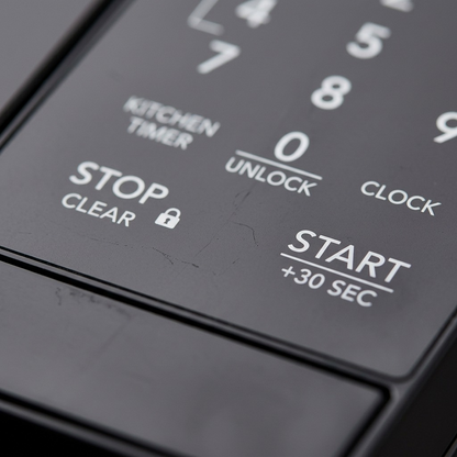 Extreme close-up view focusing on the primary START +30 SEC and STOP CLEAR buttons on the control panel, with clear print and text and shallow depth of field.