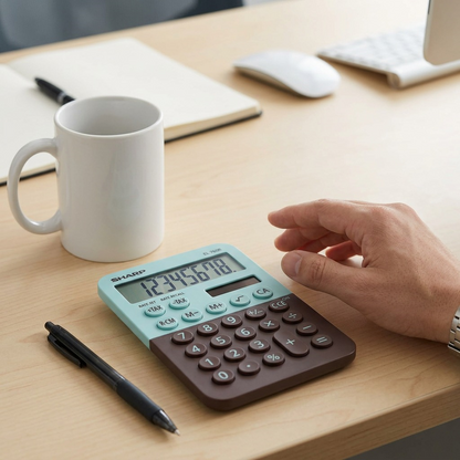 A SHARP EL760R mint chocolate calculator is placed on a light wood desk beside a standard coffee mug and ballpoint pen, demonstrating its true size. The calculator is shown exactly as seen in [image_0.png].