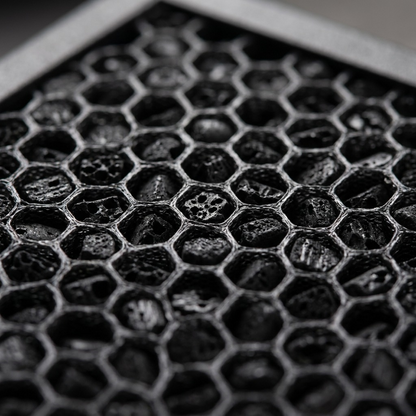A detailed macro view showcasing the precise hexagonal structure and dense porousness of the SHARP activated carbon filter material.
