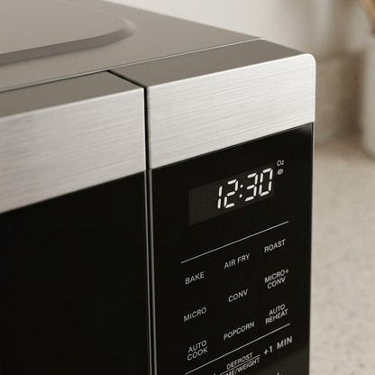 Close-up of the Sharp SMC0985KSC control panel showing the digital clock and brushed metal finish.
