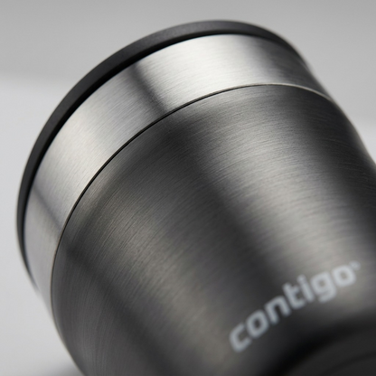 Extreme close-up of the textured charcoal gray finish and "contigo" logo on a metal tumbler.