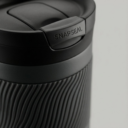 Macro close-up focusing on Contigo SNAPSEAL lid and textured rubber grip on gray tumbler.