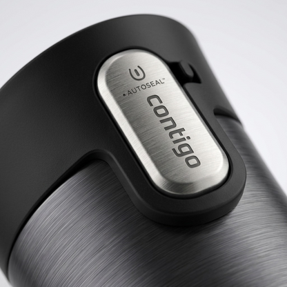 Macro view of the AUTOSEAL button on a black and grey Contigo travel mug, emphasizing its texture.