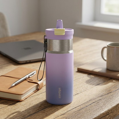 A Contigo travel bottle sits on a natural oak wood desk with a leather-bound notebook and a laptop, in soft, natural morning light.