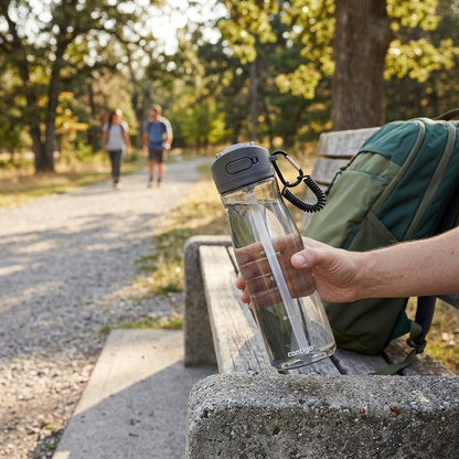 A Contigo Ashland 2.0 water bottle sits on a park bench.