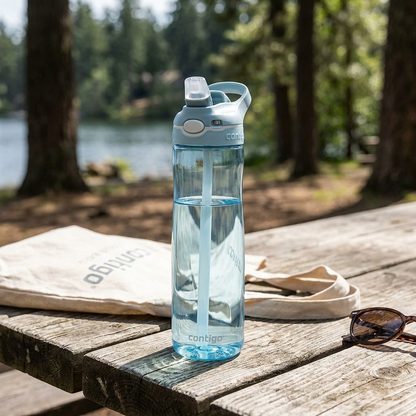 Lifestyle photograph: Contigo Ashland 2.0 water bottle on a textured wooden picnic table by a lake.